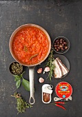 Ingredients for tomato sauce and puree in saucepan, overhead view