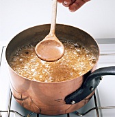 Boiling apricot glaze in pot for preparation of dessert, step 2