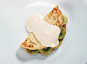 Crepes with kiwi and zabaglione on white background
