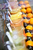 Krüge mit frisch gepresstem Orangensaft hinter verschiedenen Orangen