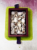 A box of sweet greetings (sugar cubes decorated with the words Happy X-Mas in chocolate)