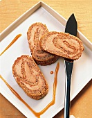 Frozen nougat roll with honey and knife on plate