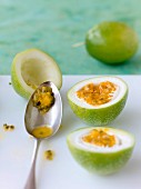 A passion fruit being scooped out