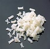 Close-up of cooked Patna rice in bone shape on black background, step 1