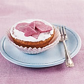 Muffins, Muffin mit Glasur und Herzchen verziert, rosa, auf Teller