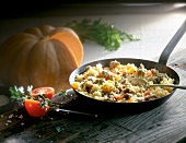 Lamb pilaf in pan with pumpkin, tomatoes and herbs