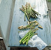 Asparagus and potato peeler on table