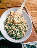 Risotto with hop shoots, small squid and parsley in serving dish
