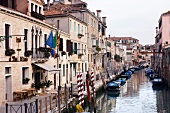 Facade of Hotel AI Mori D'Oriente and boats moored in narrow canal, Venice, Italy