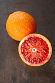 Close-up of whole and halved blood oranges