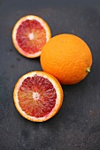 Close-up of whole and halved blood oranges