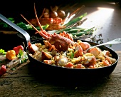 Paella and crawfish with lantern chilli and spring onions in pan