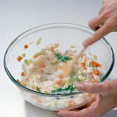 Close-up of hand mixing ingredients in bowl, blurred motion, step 3