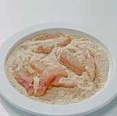 Close-up of fish fillets in breadcrumbs on plate, step 3