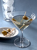 Close-up of dry martini with skewered olives