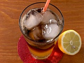 Long iceland iced tea in glass with half lemon besides it