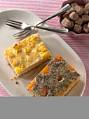 Pieces of cottage cheese and poppy seed cake and mango cream cake in serving dish