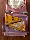 Pieces of apricot cream cake and orange cheese cake in serving dish