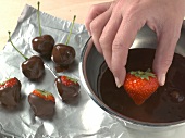 Close-up of strawberries being dipped in chocolate