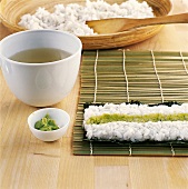 Sushi - Wasabipaste wird in Reis mitte gestrichen