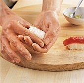 Sushi - Sushi-Reis wird zu einem länglichen Kloß geformt