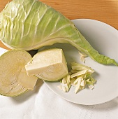 Whole and halved large cabbage on plate