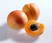 Whole and halved apricots on white background