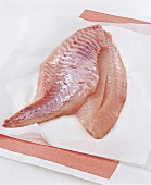 Deboned raw fish on white baking paper