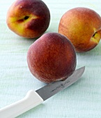 Close-up of peach and knife