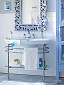 Bathroom with white washbasin, ornate mirror and blue bathroom cabinet