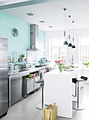 Mint white table with bar stools and wall light in modern stainless steel kitchen