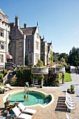 View of hotel Bovey Castle with garden and loungers in front, Devon, UK