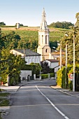 Häuser, Kirchturm im französischen Dorf, Weinberg im Hintergrund