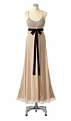 Cream silk gown with black bow around waist on mannequin