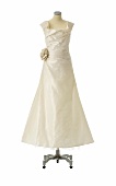 Champagne coloured ball gown with large fabric flower on mannequin