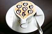 Tasse Kaffee, Milchschaum mit Schokoladenherzen verziert
