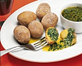 Whole and halved wrinkled potatoes with coriander on plate