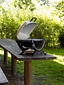 Electric grill on wooden table in park