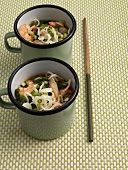 Mie noodle soup with shrimps, spinach and spring onions in cups