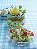 Tax mex layer salad in glass bowl with artichoke tuna salad