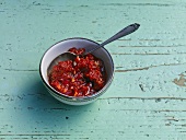 Bowl of harissa spice paste on wooden background