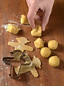 Close-up of hand rolling dough and making shapes for preparation of biscuits