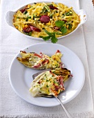 Chicory gratin ham in casserole and macaroni gratin on plate