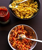 Curry rice pasta salad in red and yellow colour in two bowls