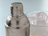 Close-up of shaker and bowl of ice cubes