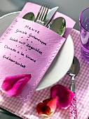 Pink cutlery bag with menu on plate