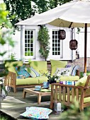 Wooden sofa set with green seat cushions and colourful scatter cushions under parasol on deck