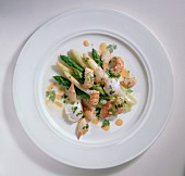 Warm asparagus salad with crayfish and quail eggs on plate