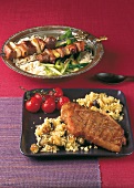 Lamb skewers with spiced rice and veal chop with couscous in serving dish