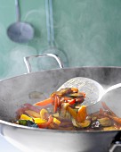 Steaming vegetables being fried in a wok